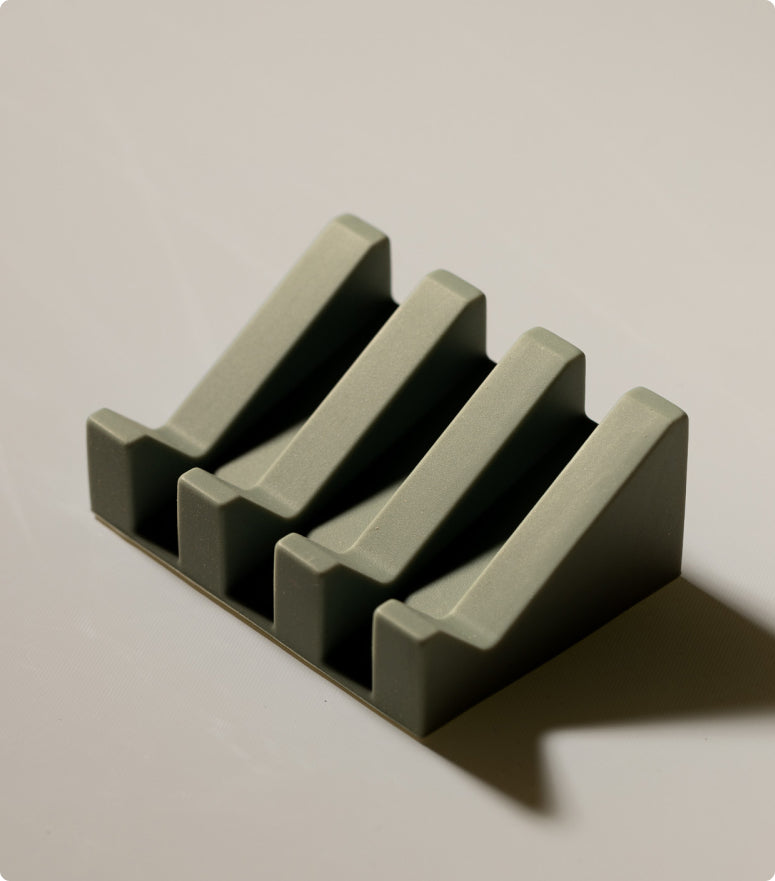 A stylish green dish for soap with a functional slotted design, combining practicality with eco-friendly elegance.