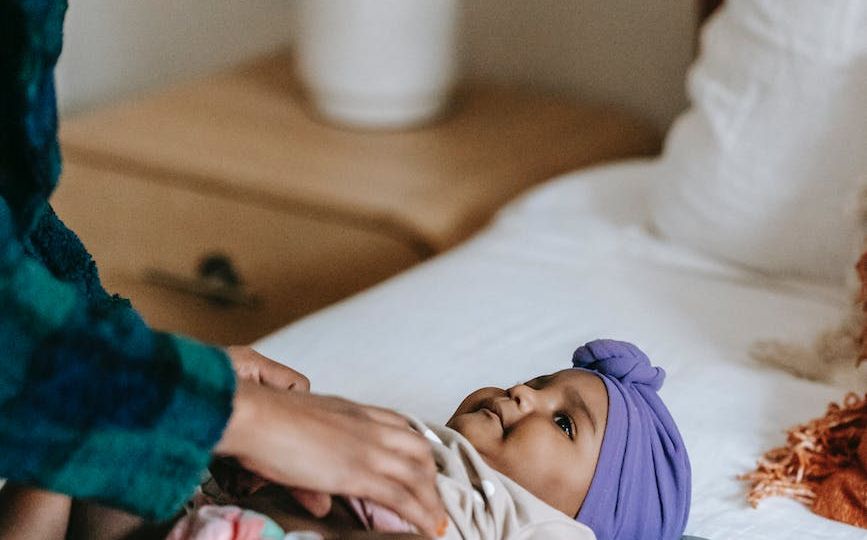 crop black mother with baby on bed